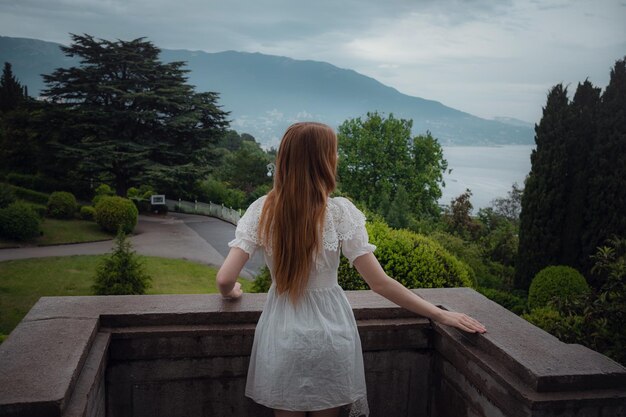 公園の外で彼女の時間を楽しんでいる魅力的な若い女性春の雨の後の美しい宮殿ジューシーな緑