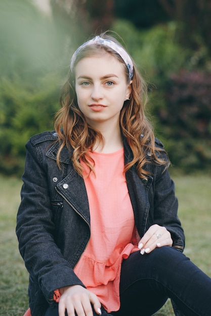 Photo attractive young woman enjoying her time outside in park with sunset