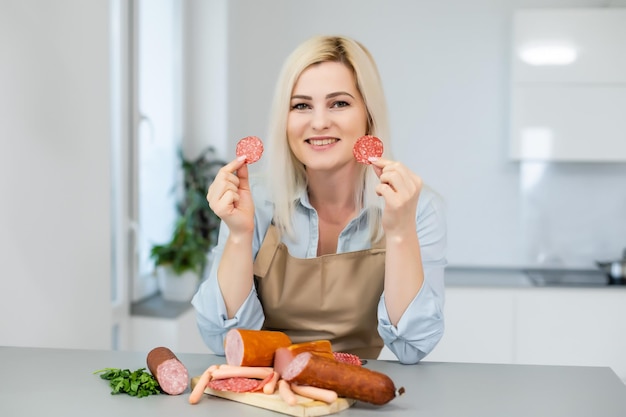 Attractive Young Woman Holding a Sausage