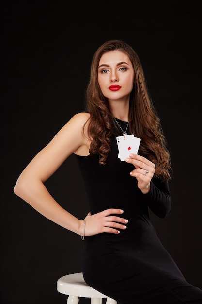 Attractive young woman holding the winning combination of poker cards