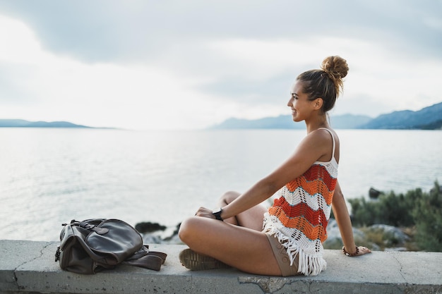 魅力的な若い女性は、地中海の素晴らしい海辺を探索しながら夏休みを楽しんでいます。