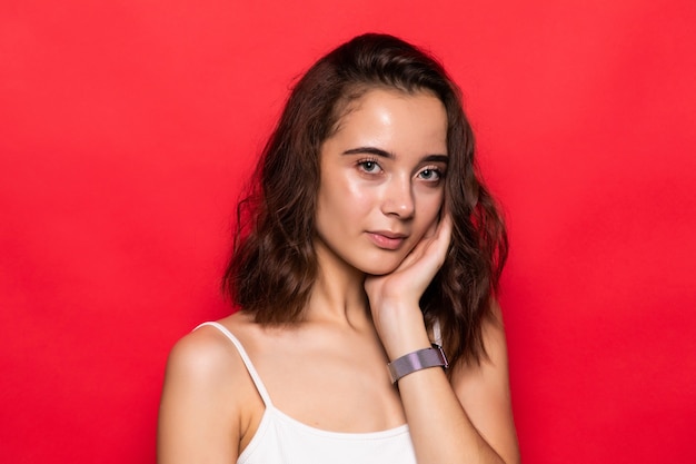 Attractive young woman isolated on red background