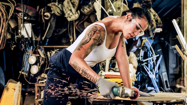 Attractive young woman mechanical worker repairing a vintage car in old garage.
