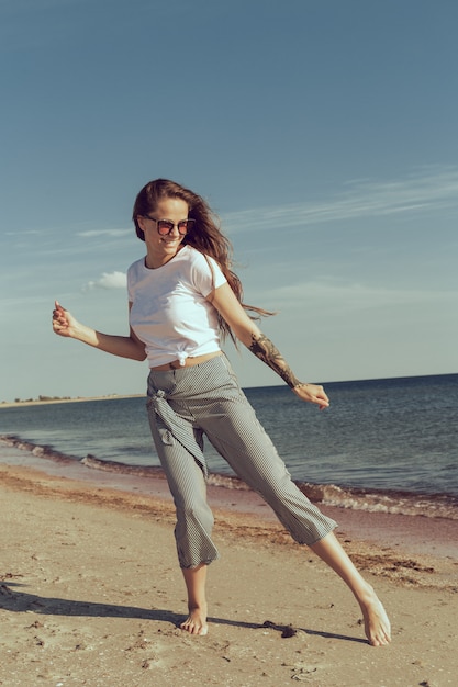 Giovane donna attraente sulla spiaggia dell'oceano al tramonto