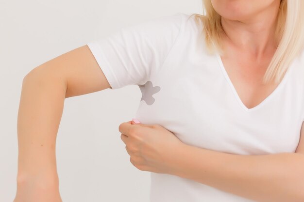 Attractive young woman pointing on her tshirt. isolated on white.