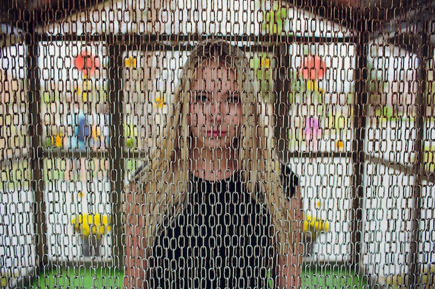 Attractive young woman posing behind the chains