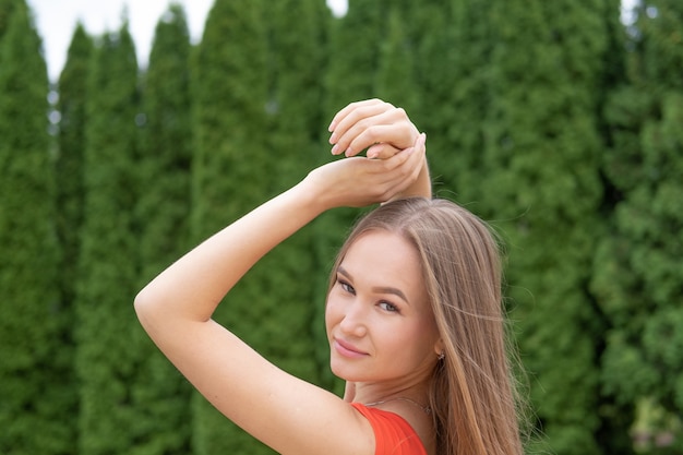 Attractive young woman posing with red dress in the park