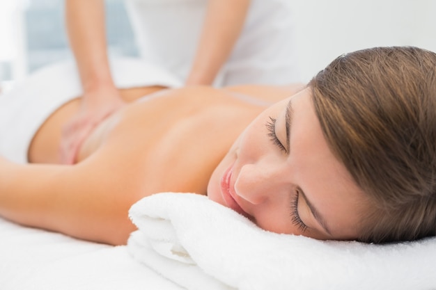 Attractive young woman receiving back massage at spa center