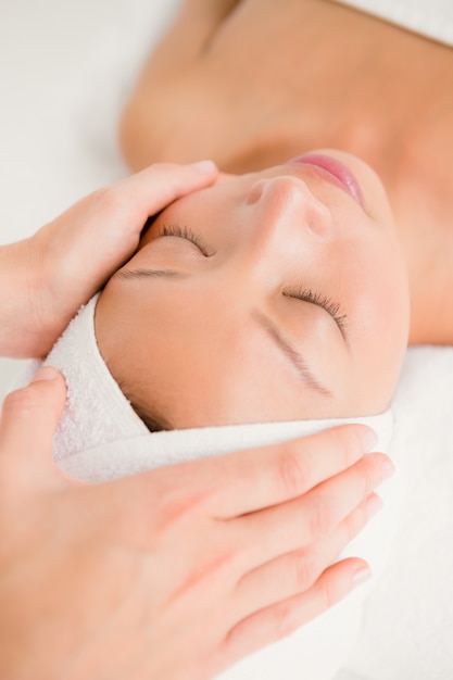 Foto attraente giovane donna che riceve massaggio sulla fronte