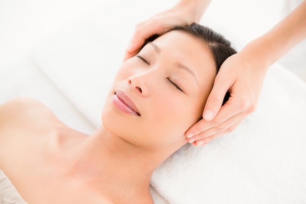 Привлекательная молодая женщина, принимая массаж головы в спа-центре