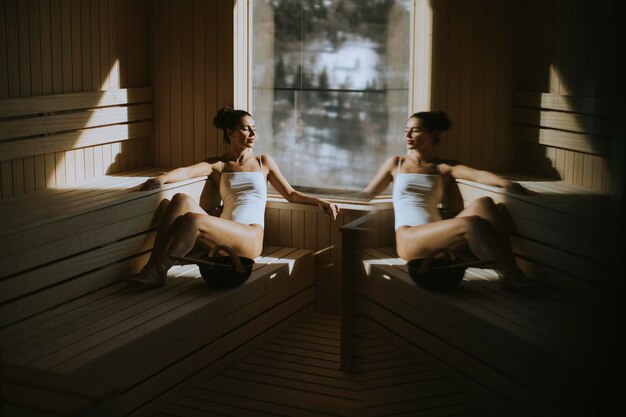 Attractive young woman relaxing in the sauna