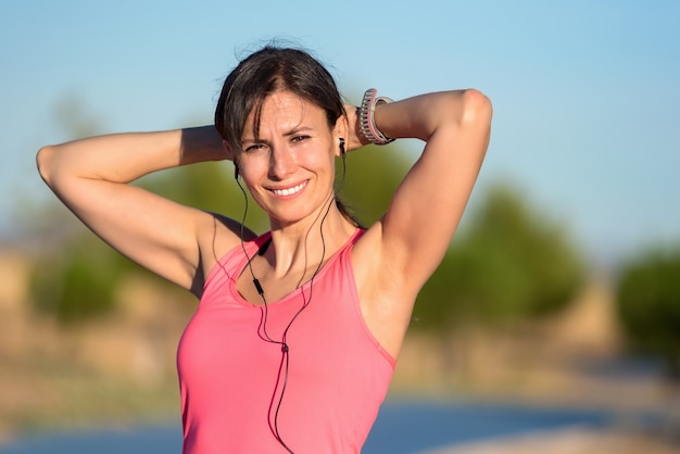 Giovane donna attraente nel sorridere dei vestiti di sport. modello di fitness