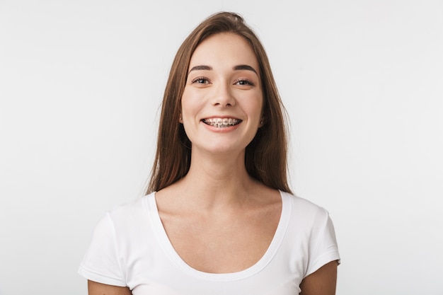 Attractive young woman standing isolated over white wall, laughing