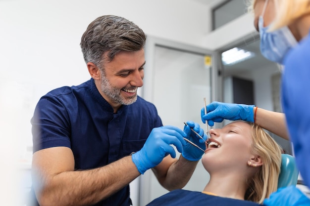 Attractive young woman in stomatology clinic with male dentist Healthy teeth concept