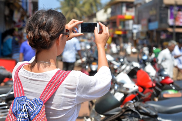 Attractive young woman taking selfie with smartphone on street