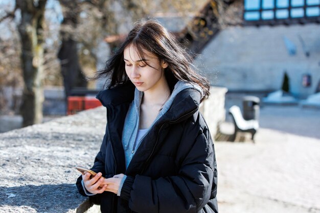 Attractive young woman texting on the street using mobile phone