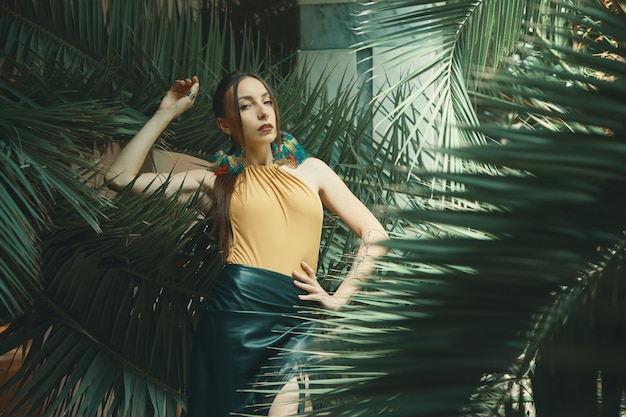 Attractive young woman among the tropical plants.