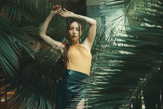 Attractive young woman among the tropical plants.