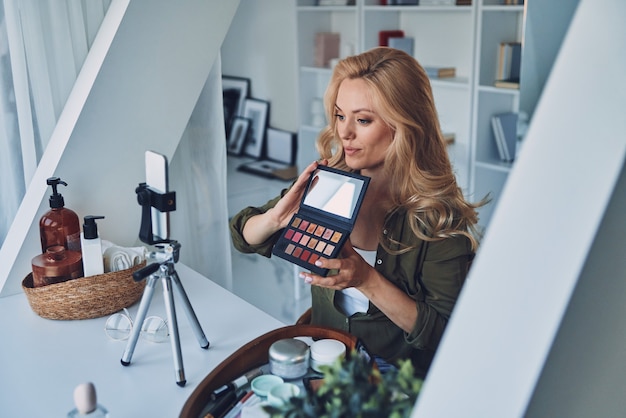 Foto attraente giovane donna che vlogging su trucchi e prodotti di bellezza