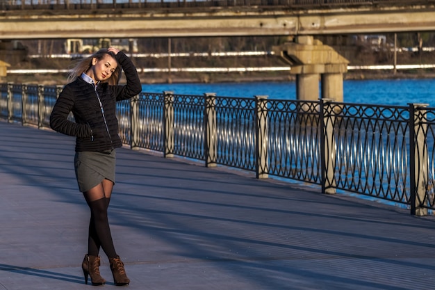 Attractive Young Woman Walking On Embankment at Sunny Day.