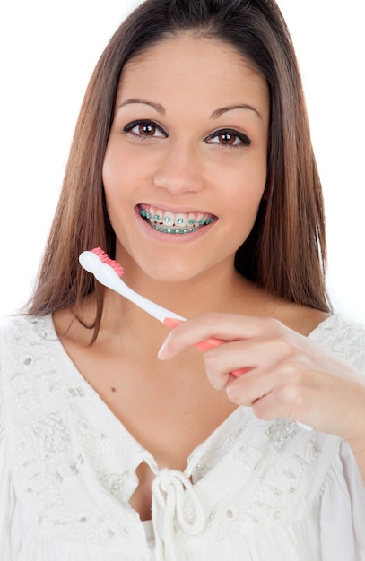 Giovane donna attraente con parentesi che pulisce i suoi denti