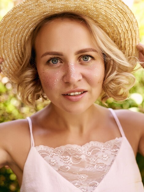 Attractive young woman with golden freckles enjoying her time outside in park with sunset in background.