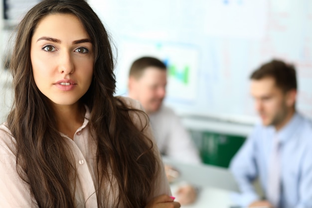 Attractive young woman with long hair standing in office