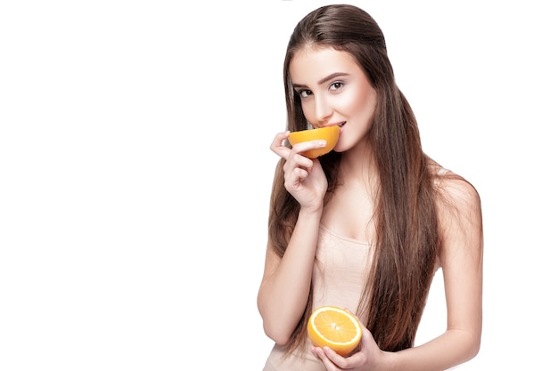 オレンジ色の背景に分離された魅力的な若い女性。健康食品