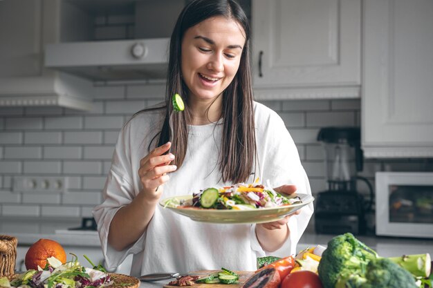 Attractive young woman with a plate of salad in the kitchen