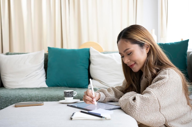 Attractive young woman working online with digital tablet at home