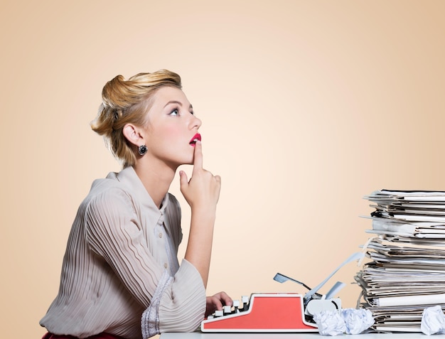 Attractive young woman working on vintage typewriter