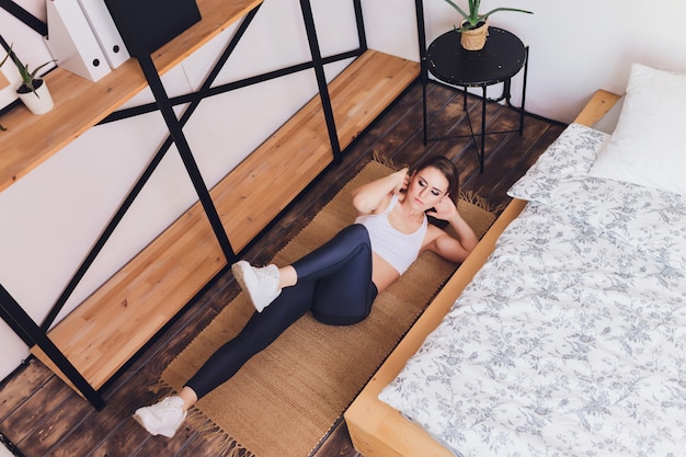 Attrctive fitness woman doing stretching exercises at home, as part of a healthy lifestyle without going to the gym.