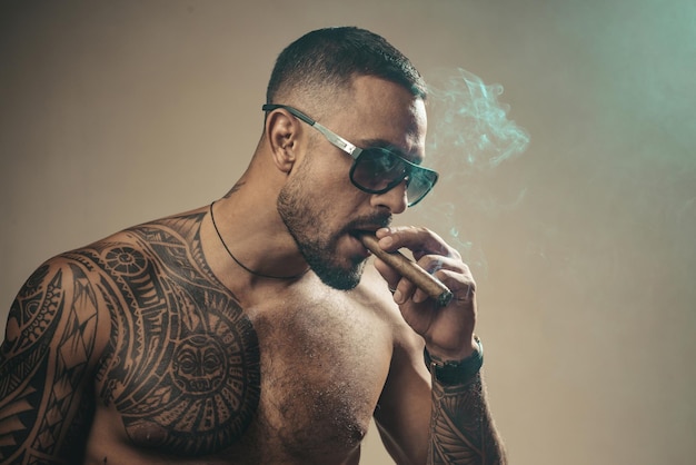 Attributes of men power strength and luxury life Strong confident tattooed man in luxury sunglasses