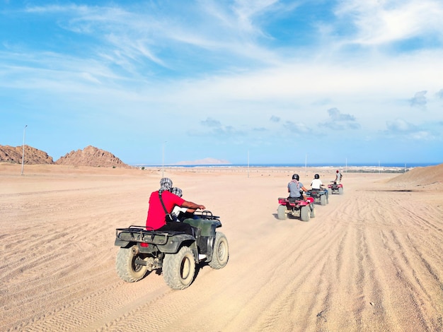 Atv rally man driving quad bike in sinai desert happy tourist having fun during summer vacation