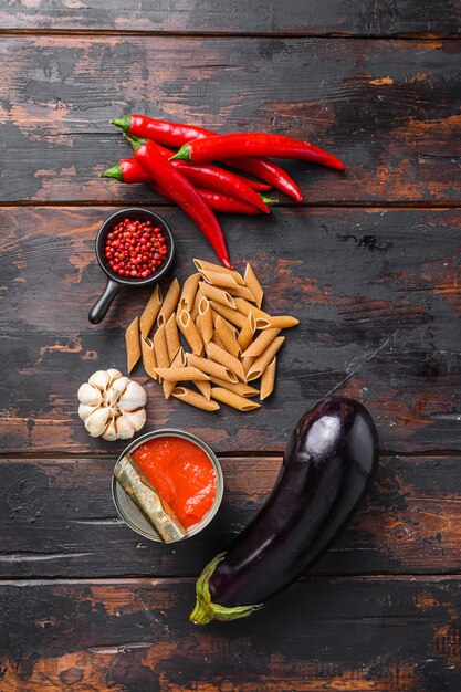 Aubergine penne ingredients eggplant pasta on old wooden table