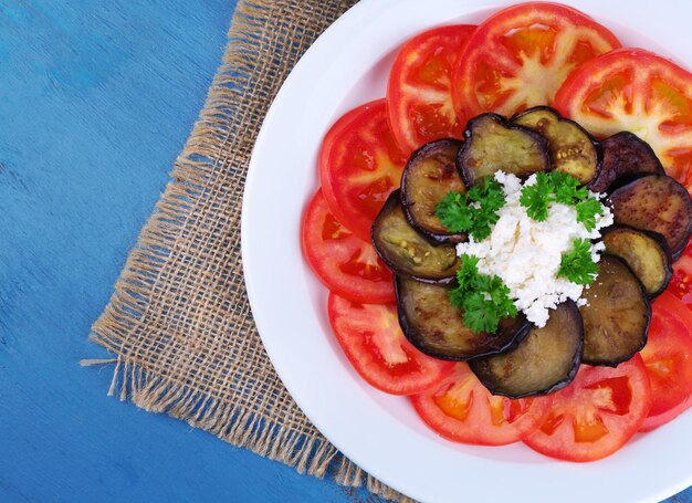 Auberginesalade met tomaten en fetakaas op houten achtergrond