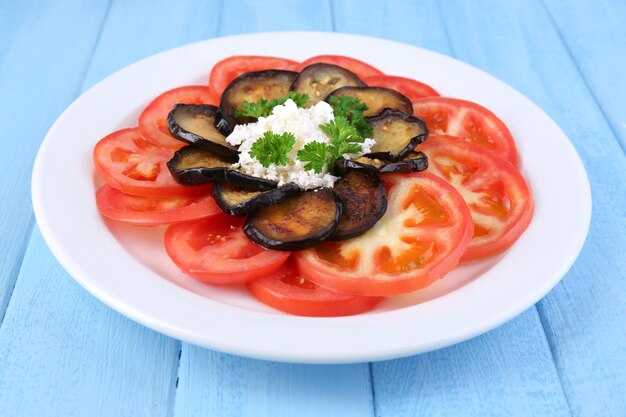 Auberginesalade met tomaten en fetakaas op houten achtergrond