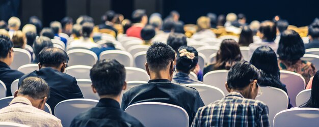 Audience listening Speakers on the stage in the conference hall or seminar meeting