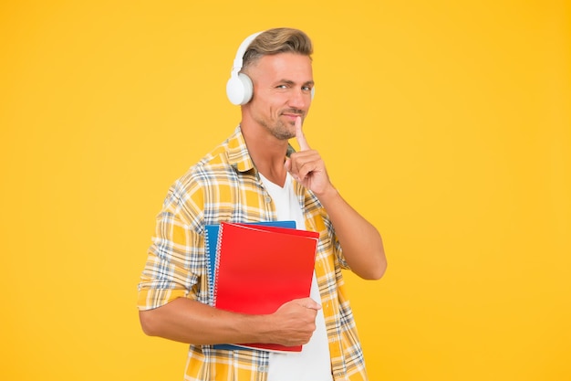 Audio bibliotheek. man knappe college student hoofdtelefoon boeken. talen studeren. een andere manier van studeren. engels leren. educatieve technologie. studie. audioboekconcept. wereldwijde toegang tot kennis.