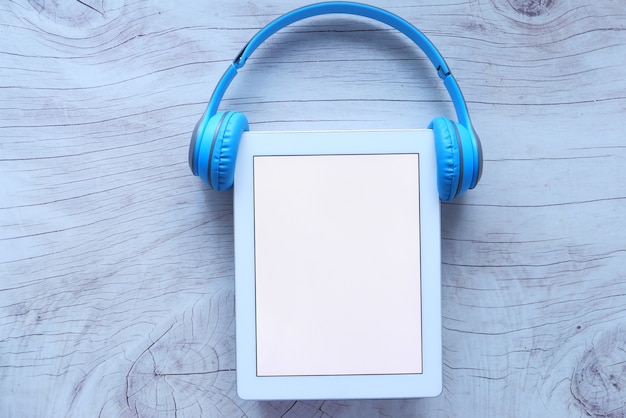 Audio book concept. headphones and digital tablet on table