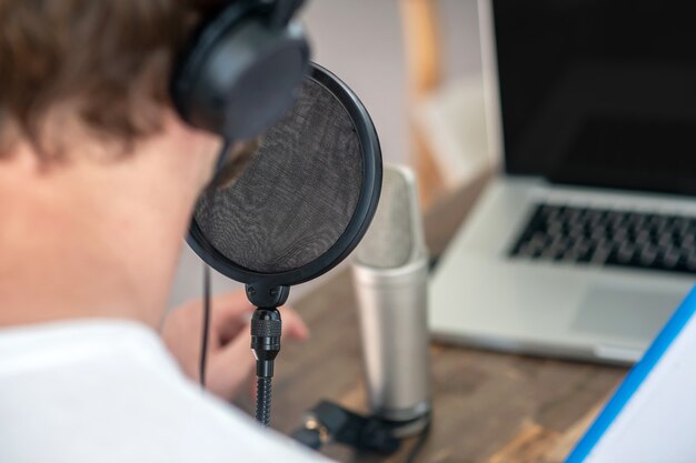 Audio conference. A young man speaking oin microphone and looking involved