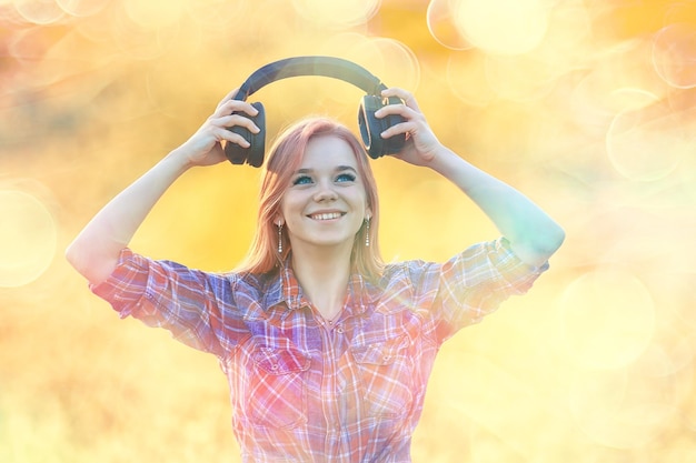 Photo audio headphones summertime girl music in a field of flowers, young female spring