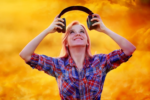 Foto cuffie audio estate ragazza musica in un campo di fiori, giovane femmina primavera