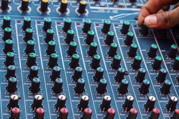 Photo audio mixing console closeup with hand