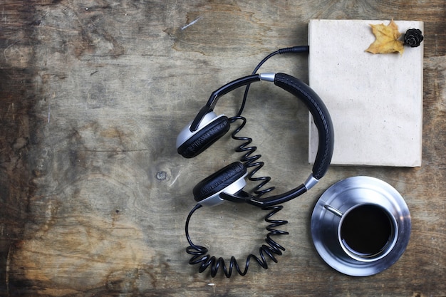 Audioboek-koptelefoon en boek op een houten tafel