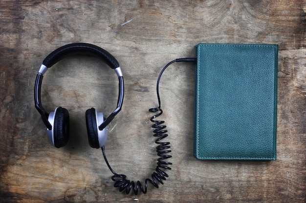 Audiobook headphones and book on a wooden table