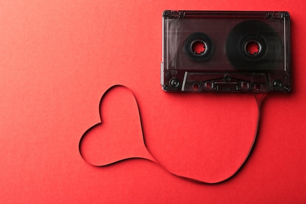 Audiocassette met magneetband in vorm van hart op rode achtergrond