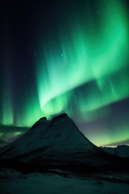 The aurora borealis gleams above a snowy mountain background