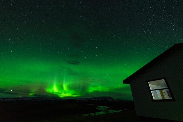 Aurora borealis lichten met rivier en huis