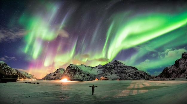 Aurora borealis (noorderlicht) over berg met één persoon